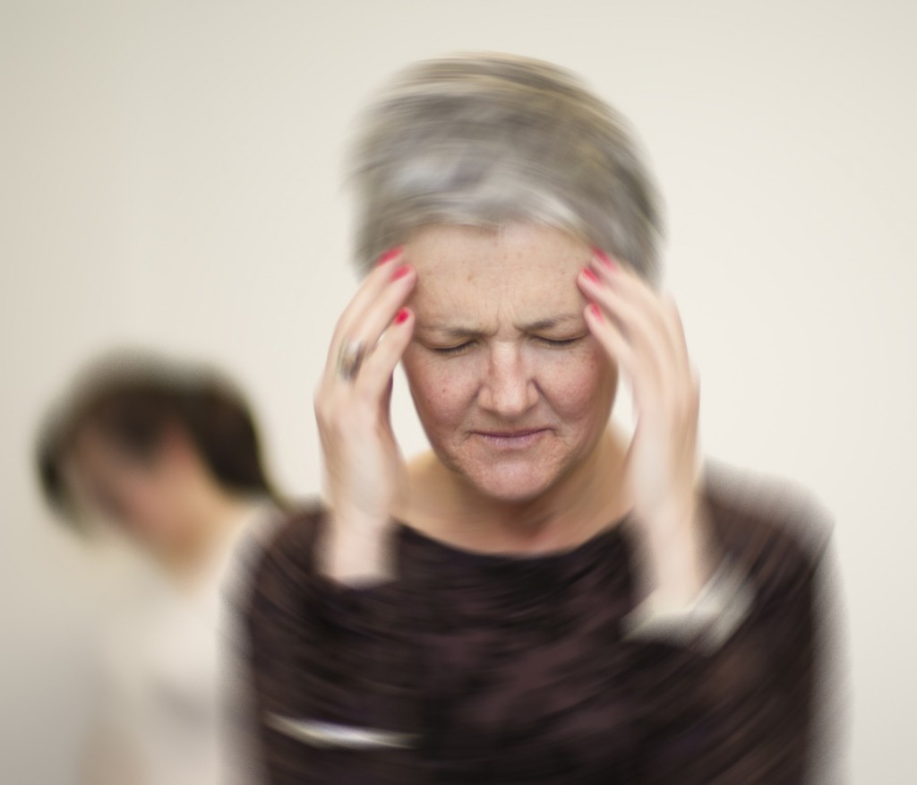 a woman holding her head feeling dizzy