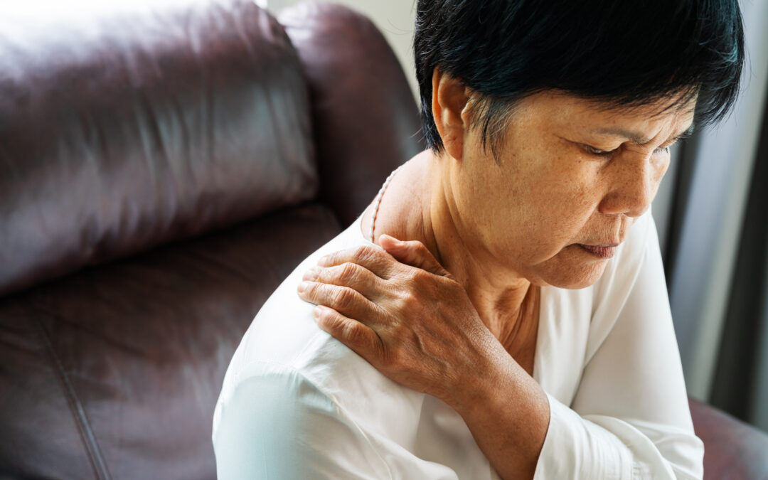 woman holding onto shoulder from pain