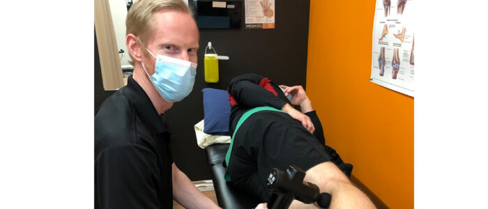wefixu port hope physiotherapy assistant russell using restoragun on patient's leg for pain relief