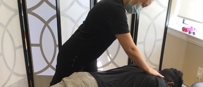 chiropractor works on patients back to relieve pain