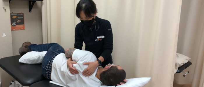 physiotherapist treats shoulder pain of patient